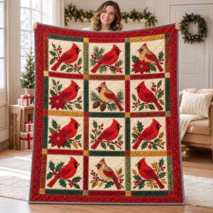 May include: A rectangular quilt featuring a grid of twelve squares, each displaying a cardinal bird perched on branches with holly, pinecones, or poinsettias. The quilt has a red border with white dots and a dark green frame.