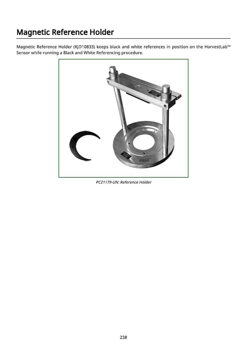 May include: A silver-colored magnetic reference holder with a circular base and a rectangular top. The holder has two vertical supports and is designed to hold black and white references. The text "PC21179-UN: Reference Holder" is visible.
