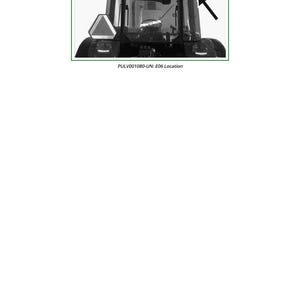 May include: Monochrome image of a tractor cab. The cab has a windscreen, side windows, and a roof with lights. A triangular warning sign is visible on the front. The text "PULV001080-UN: E06 Location" is printed below the cab.