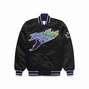 May include: Black satin bomber jacket with the text "Devil Rays" in a gradient of blue, green, and yellow. The jacket has a purple collar and cuffs with white stripes. A logo of a stingray is on the front.