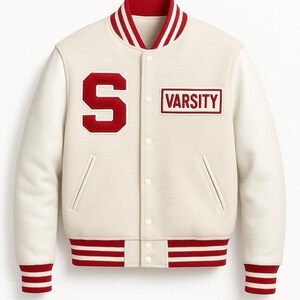 May include: Cream-colored varsity jacket with red accents. Features a red "S" on the left chest and "VARSITY" in a red rectangle on the right. Red and white striped details on the collar, cuffs, and hem. A classic athletic-inspired jacket.