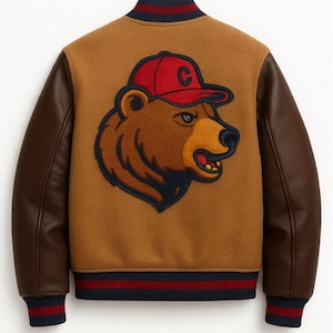 May include: A brown varsity jacket with brown leather sleeves. The back of the jacket features a bear wearing a red baseball cap with a white "C" on it. The jacket has a navy blue, red, and white striped collar, cuffs, and hem.