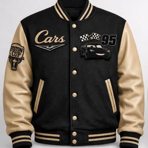 May include: Black varsity jacket with tan leather sleeves. Features the word "Cars" in gold script, a "95" patch, and a cartoon car graphic. Includes a "Piston Cup" patch on the left sleeve. The jacket has a black collar and cuffs with gold stripes.