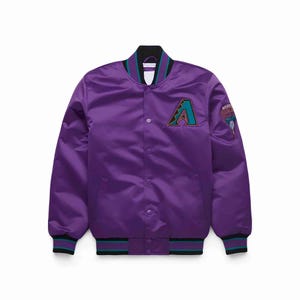 May include: A purple satin bomber jacket with a black and teal striped collar, cuffs, and hem. The jacket features a large teal and brown letter "A" patch on the chest and a team logo patch on the sleeve.
