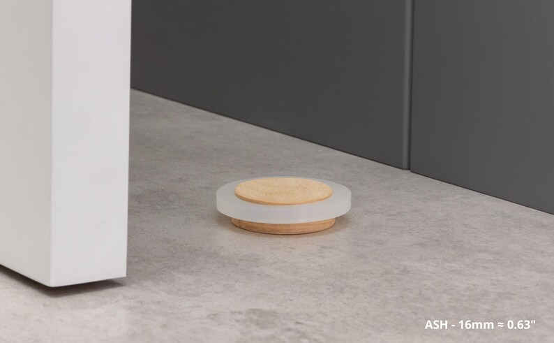 May include: A round, decorative soap dish with a wooden base, a frosted white middle section, and a light-colored wooden top. The dish is approximately 0.63 inches in height. The background is a neutral gray.