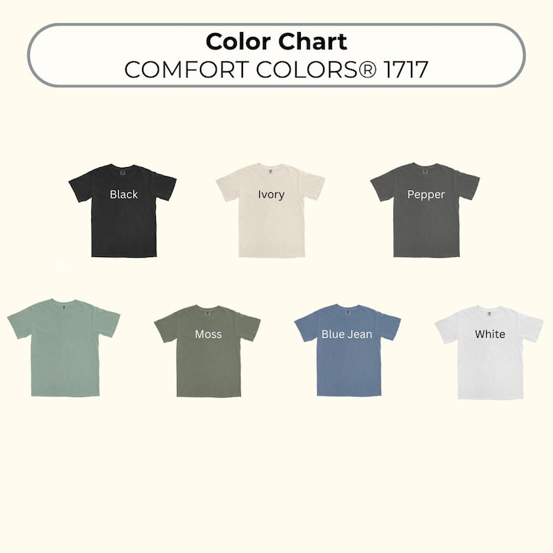 May include: A color chart for Comfort Colors 1717 t-shirts displaying seven short-sleeve shirts in various colors. The colors labeled are Black, Ivory, Pepper, a light green, Moss, Blue Jean, and White, arranged in two rows on a light background.