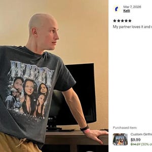 May include: A dark gray short-sleeve crew neck t-shirt featuring a graphic print with the word WIFEY in large metallic-style lettering above a collage of multiple photographs of a person, with small sparkling star accents at the bottom.