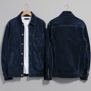 Puede incluir: Dos chaquetas de pana azul marino, una vista frontal y otra trasera, colgadas de perchas de madera. La chaqueta frontal tiene cierre de botones, bolsillo en el pecho y bolsillos laterales. Se ve una camiseta blanca debajo. Estilo clásico y casual.