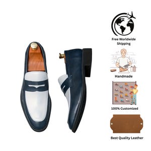 May include: Navy and white leather loafers with a classic design. The shoes have a white vamp and a navy body. The shoes are displayed with wooden shoe trees. The image also includes icons for worldwide shipping, handmade, and best quality leather.