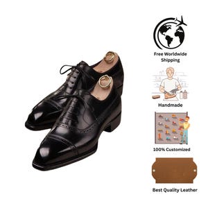 Op de afbeelding: Een paar zwarte leren Oxford-schoenen met een kapteen en brogue-details. De schoenen hebben veters en worden gepresenteerd met houten schoenspanners. De afbeelding bevat ook de tekst "Handmade", "100% Customized" en "Best Quality Leather".