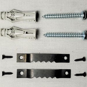 May include: Hardware kit with two gray plastic wall anchors, two silver screws, two black sawtooth hangers, and four small black screws. The components are arranged on a white fabric surface.