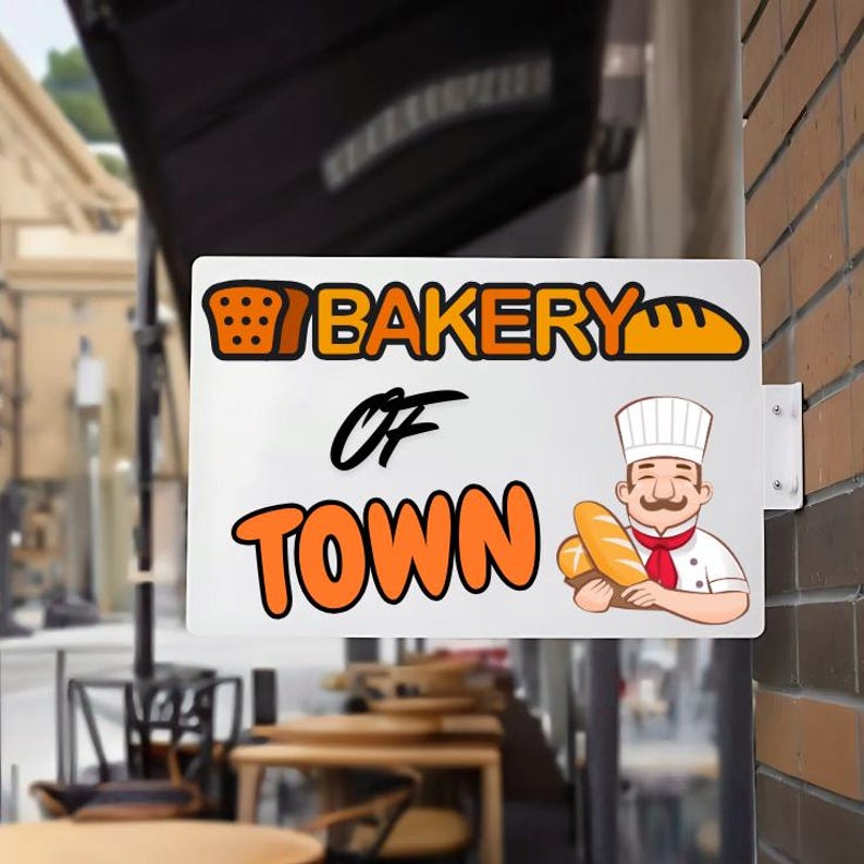 Peut inclure: Panneau rectangulaire blanc pour une boulangerie, fix&eacute; sur un mur de briques. Le panneau affiche les mots "Bakery of Town" en orange et noir, avec des illustrations de pain et d'un chef tenant des miches.