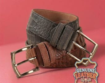Può includere: Tre cinture in pelle marrone e grigia, con fibbie color argento. Le cinture presentano motivi strutturati, tra cui un design simile a quello del coccodrillo. Un'etichetta con la scritta "GENUINE LEATHER" è visibile.