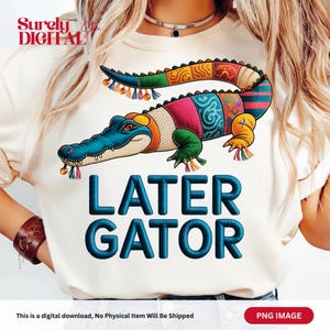May include: Cream-colored t-shirt featuring a colorful alligator design with the text "LATER GATOR" in blue. The alligator is decorated with various patterns and colors, including blue, green, pink, and orange. The shirt is a digital download.