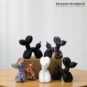 Könnte beinhalten: Ein Set aus sechs Ballonhund-Skulpturen in verschiedenen Farben und Mustern, darunter Schwarz, Weiß, Gold und ein mehrfarbiges Design. Die Skulpturen sind aus Keramik gefertigt und haben eine glänzende Oberfläche. EleganceSculpted ist auf dem weißen Hintergrund gedruckt.