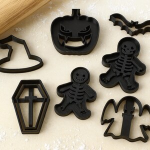 Puede incluir: Un conjunto de cortadores de galletas negros con temática de Halloween. El conjunto incluye formas de sombrero de bruja, calabaza, murciélago, ataúd, esqueleto, esqueleto de pan de jengibre y fantasma.