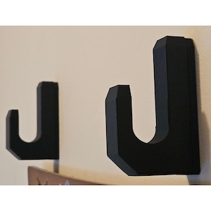 Soporte de pared para espadas: Expositor de plástico duradero con tornillos ocultos, ideal para exhibir espadas.
