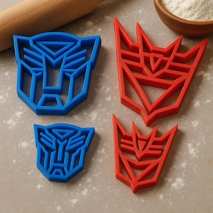 May include: Four plastic cookie cutters in blue and red, featuring the Autobot and Decepticon symbols. The cutters are in two sizes, with the Autobot symbol in blue and the Decepticon symbol in red. The cutters are designed for baking.