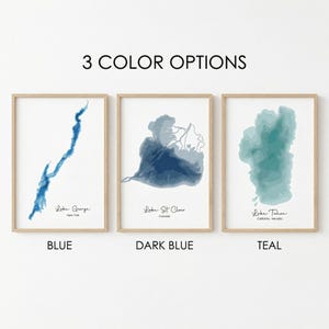 May include: Three framed prints displaying lake topography in blue, dark blue, and teal. Each print features a different lake: Lake George, Lake St. Clair, and Lake Tahoe. The text "3 COLOR OPTIONS" is at the top, with colour names below.