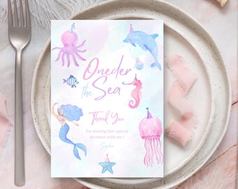 May include: A watercolor invitation card with a mermaid theme. The card features illustrations of sea creatures like a mermaid, octopus, dolphin, seahorse, and jellyfish, all wearing party hats. The text reads "One-der the Sea" and "Thank You".