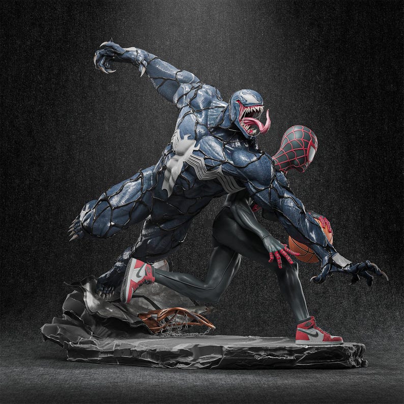 May include: A dynamic statue featuring Venom and Spider-Man in action. Venom, in dark blue with white accents, lunges towards Spider-Man, who wears a red and black suit and red trainers. The base is a textured grey stone.