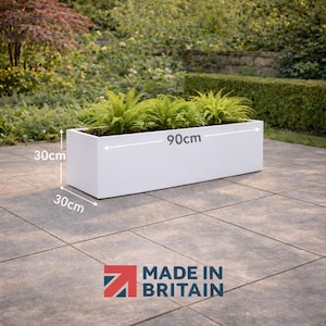 May include: A white rectangular planter box, 30cm high, 30cm wide, and 90cm long, filled with green plants. The image includes the text "MADE IN BRITAIN".