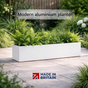 May include: A white rectangular aluminium planter filled with green plants. The planter is modern and sits on a patio. Text on the image reads "Modern aluminium planter" and "Made in Britain."