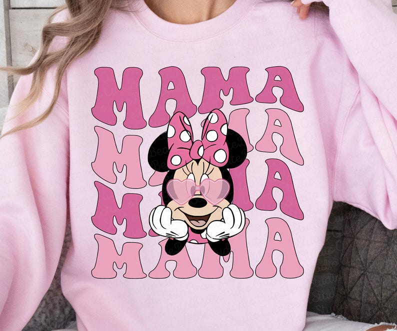 May include: Pink sweatshirt with a pink and white cartoon mouse wearing sunglasses and a bow. The text "MAMA" is repeated in a stacked pattern on the shirt.