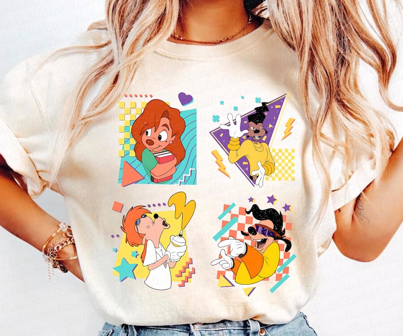 May include: A white t-shirt with a retro-style graphic featuring four cartoon characters from the Disney movie 'A Goofy Movie'. The characters are Goofy, Max Goofy, Roxanne, and Pete. The graphic is surrounded by colorful geometric shapes.