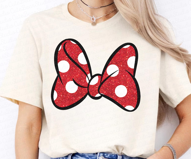 May include: A white t-shirt with a red and white polka dot bow printed on the front.