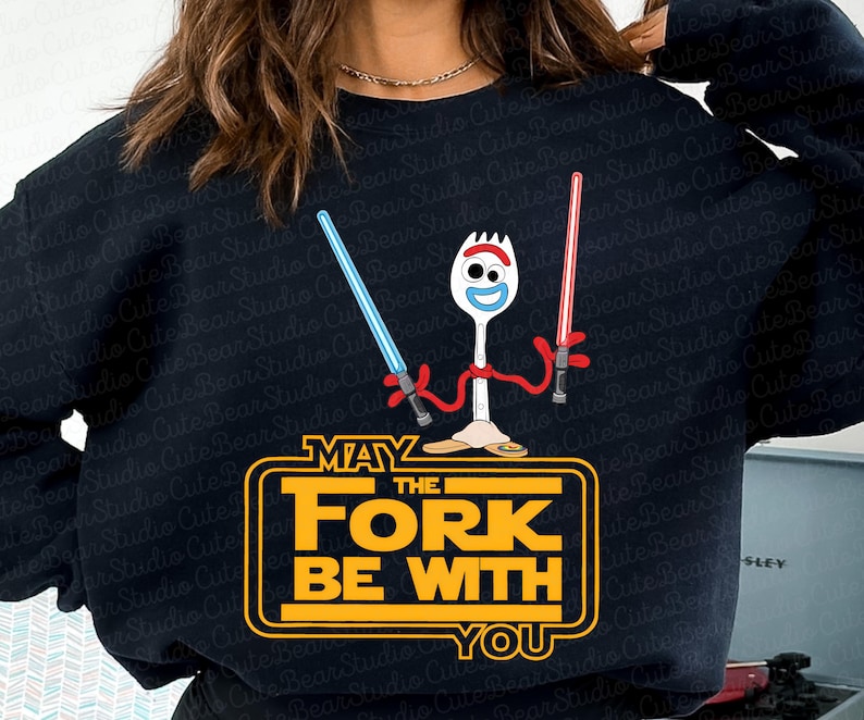 May include: Black sweatshirt with a yellow graphic of a toy character holding lightsabers. The graphic says "May the Fork Be With You".