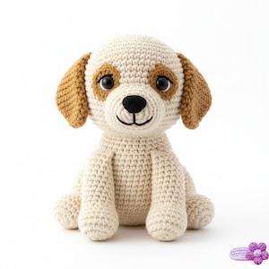 Può includere: Un giocattolo per cani all'uncinetto color crema e marrone. Il cane ha macchie marroni intorno agli occhi e sulle orecchie, con un naso nero e una bocca sorridente. Il giocattolo è seduto in posizione eretta con le gambe distese. Lo sfondo è bianco.