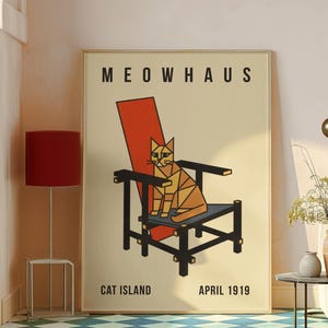 Op de afbeelding: Een poster met de tekst "MEOWHAUS" en "CAT ISLAND APRIL 1919". De poster toont een geometrische kat die op een zwarte stoel met een rode rugleuning zit. De achtergrond is beige.