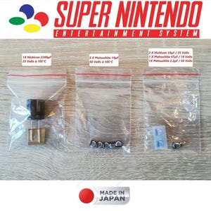 Puede incluir: Tres bolsas de plástico transparente que contienen componentes electrónicos para una Super Nintendo Entertainment System. Las bolsas están etiquetadas con el tipo de componente, la capacitancia, el voltaje y la clasificación de temperatura. Las etiquetas también incluyen el nombre del fabricante, Nichicon y Matsushita.