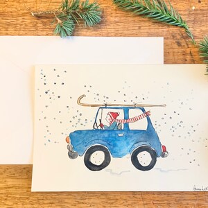 Handgeschilderde kerstkaart voor de wintervakantie. Originele Aquarel art. 5x7 blanco winter vakantie wenskaart. Sneeuw. Rodelen. Slee rijden.