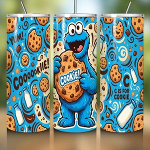 May include: A cylindrical tumbler with a bright blue background featuring a pattern of chocolate chip cookies, milk bottles, and a large blue furry monster holding a cookie. The text reads YUM, COOOOOKIIE, COOKIE, and C IS FOR COOKIE.