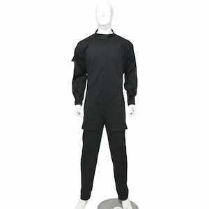 Può includere: Tuta nera con maniche lunghe e collo alto. L'indumento intero presenta due tasche anteriori sui pantaloni e una tasca sulla manica sinistra. La tuta è esposta su un manichino bianco.