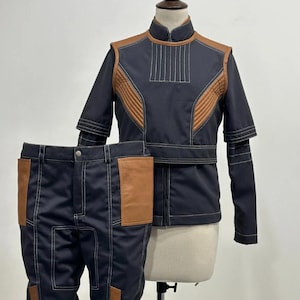 May include: A two-piece costume set featuring a navy blue jacket and pants. The jacket has brown accents and white stitching. The pants have brown pockets and white stitching. The costume is displayed on a mannequin.