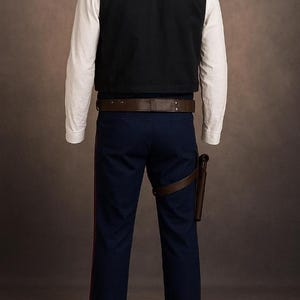 May include: A costume featuring a black vest over a white long-sleeve shirt, paired with navy blue pants with a red stripe. A brown belt and holster complete the outfit. The costume is designed to resemble a character from a science fiction film.