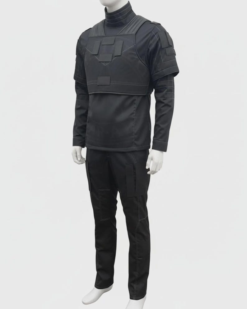 May include: A black tactical outfit displayed on a mannequin. The outfit includes a long-sleeved shirt, tactical vest, and pants. The vest has multiple pockets and panels. The pants have pockets on the sides and knees. The outfit is designed for protection and utility.