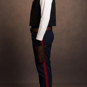 May include: A costume consisting of a black vest, white shirt, and navy blue pants with a red stripe. A brown holster and belt complete the outfit. The costume is displayed on a mannequin.