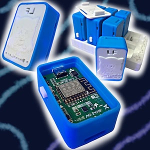 Puede incluir: Carcasas azules para dispositivos electrónicos con tapas blancas, algunas abiertas para revelar placas de circuito. Una carcasa tiene un diseño de personaje de dibujos animados y el texto "TAJHAYA". Otra tiene las letras "LF" y un diseño de gato.