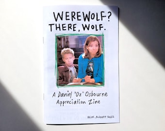 Op de afbeelding: Een witte zine met de titel "WEREWOLF? THERE, WOLF." in zwarte marker. De zine bevat een foto van twee mensen, een man en een vrouw, in een groen kader. De tekst onder de foto luidt "A Daniel "Oz" Osbourne Appreciation Zine" en "BECK ANDOFF 2022".