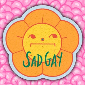 May include: A sticker with a cartoon flower design. The flower has orange petals and a yellow centre, with a sad face and the words "SAD GAY" in green. The sticker is set against a pink background.