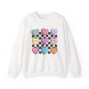 May include: White sweatshirt with a checkered pattern and colorful candy hearts with different phrases on them, including "Chicago Soft Core", "Patrick", "Emo 4ever", "Pete", "FOB", "Andy", "Hey Sugar", "Joe", and "Where is Your Boy".