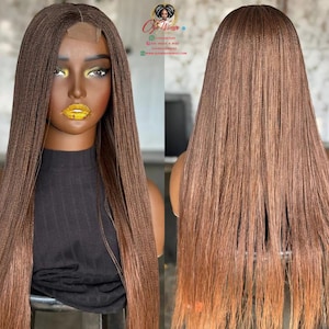 May include: A brown braided wig with a lace front is displayed on a mannequin. The wig features long, straight braids with a gradient effect, transitioning from a darker brown at the roots to a lighter, reddish-brown at the ends. The mannequin is wearing a black top.