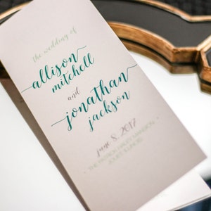 May include: A wedding invitation with the text "The wedding of Allison Mitchell and Jonathan Jackson" in teal script font. The date "June 8, 2017" is printed below the names.
