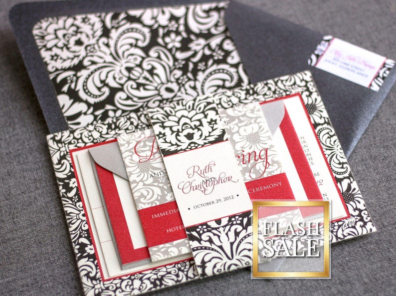 May include: Black and white damask patterned wedding invitation with red accents. The invitation includes the names "Ruth and Christopher" and the date "October 29, 2012".