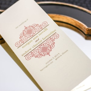 May include: A wedding invitation with a cream background and gold lettering. The invitation features a red and gold design with the text "the wedding of morgan ann novelli and andrew vincent ferrentino" and the date "october 5, 2015".