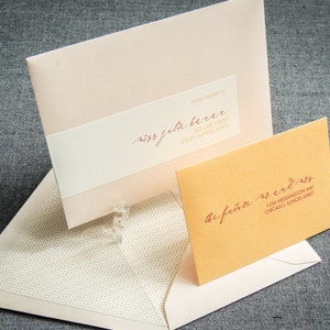 May include: Two envelopes, one pink and one orange, with handwritten addresses. The pink envelope has the text "Please Drama To" and "Miss Jela Berar" with the address "200 Lake Street,  Jouet, Illinois 60451". The orange envelope has the text "The Future Mr. & Mrs." with the address "1234 Weddington Way, Chicago, Illinois 60451".